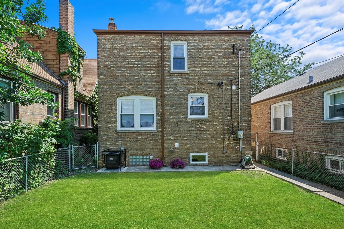 Rear masonry elevation and yard, finished. The housing stock in Austin is mostly brick two-flats.